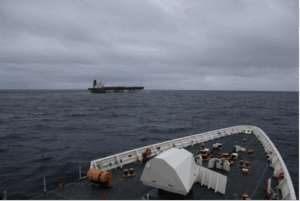 The US Coast Guard closing in on the Russian tanker Marinera. The trajectory towards sea-based escalation narrows the gap between grey zone and combat operations.Image source: Wikimedia Commons.